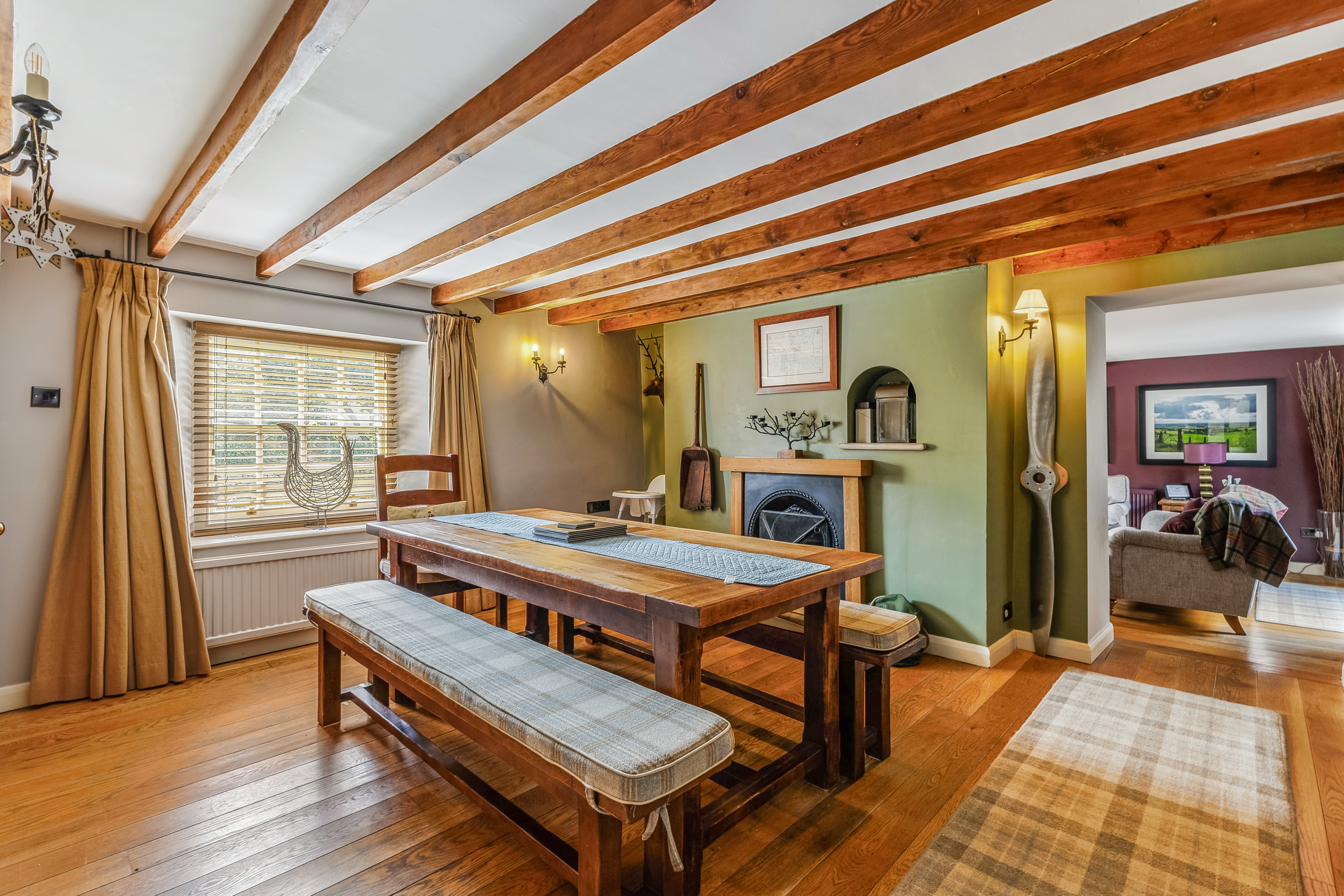 Oak-beamed dining room with solid oak rectory table at Yew Tree Cottage Westow